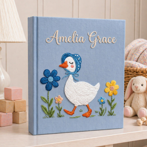 Personalized hand embroidered photo album featuring a bonnet goose walking through a whimsical storybook flower garden