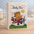 Personalized hand embroidered photo album featuring a teddy bear pilot flying a vintage red airplane beneath clouds and sunshine on a premium linen cover