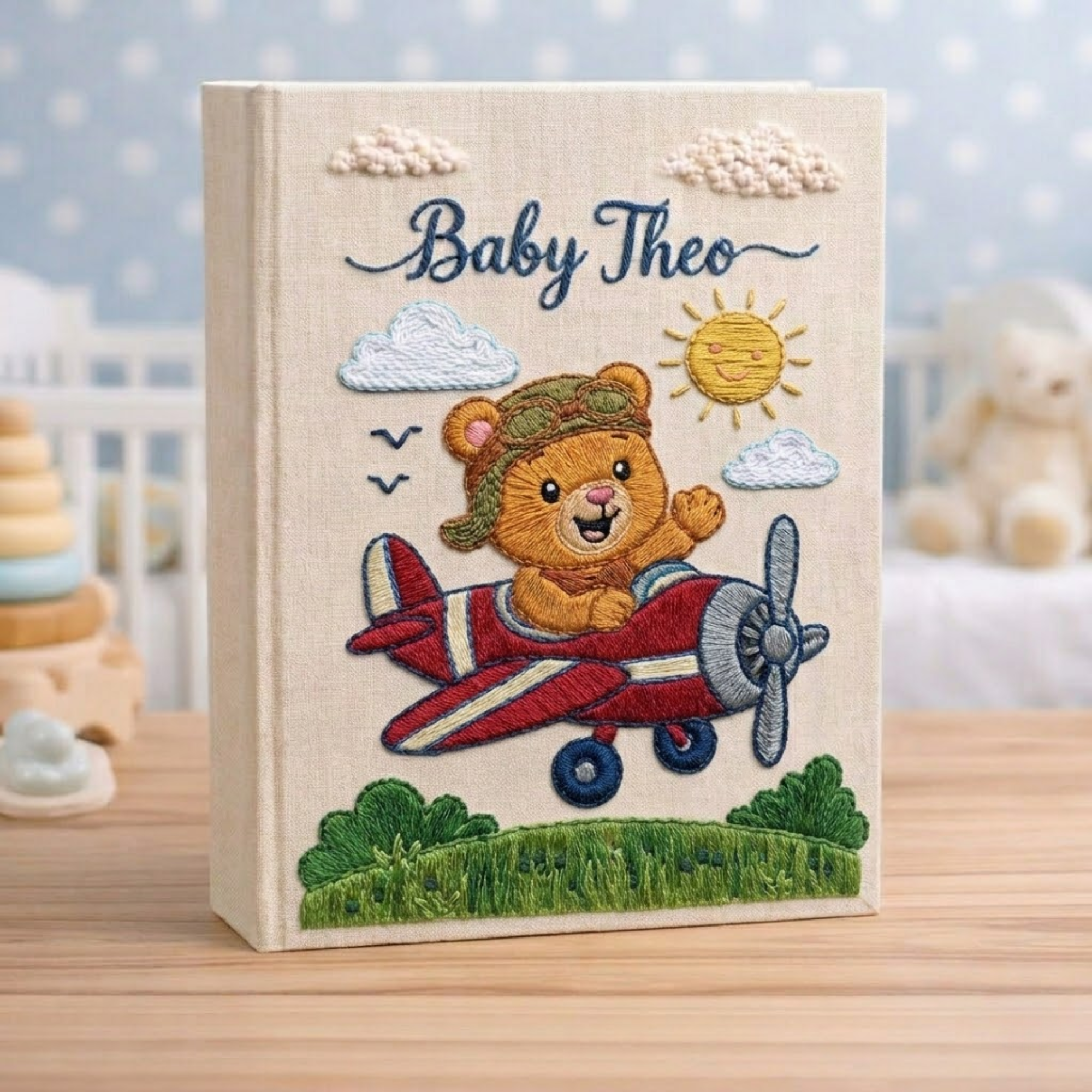 Personalized hand embroidered photo album featuring a teddy bear pilot flying a vintage red airplane beneath clouds and sunshine on a premium linen cover