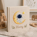 Personalized hand embroidered baby photo album with astronaut sitting on crescent moon and stars nursery design