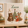 Personalized hand embroidered photo album featuring woodland animals including a bear fox and deer gathered around a teepee on a linen cover