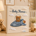 Personalized embroidered baby photo album featuring teddy bear astronaut riding a space rocket with fluffy clouds