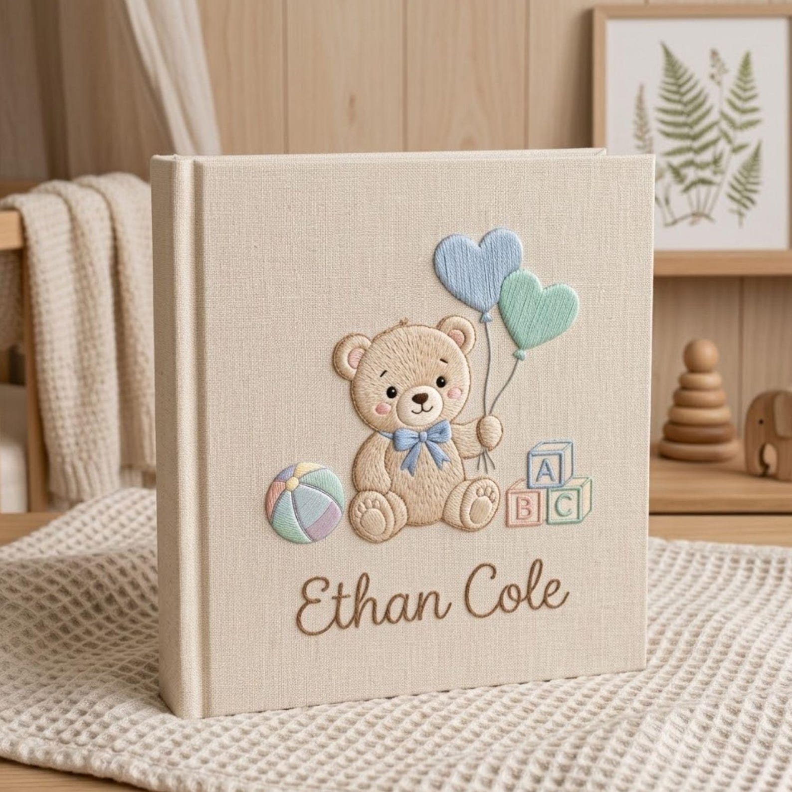 Personalized hand embroidered photo album featuring a teddy bear holding heart-shaped balloons with alphabet blocks and custom baby name