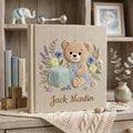 Personalized hand embroidered photo album featuring teddy bear in blue overalls with alphabet block and floral details on linen cover