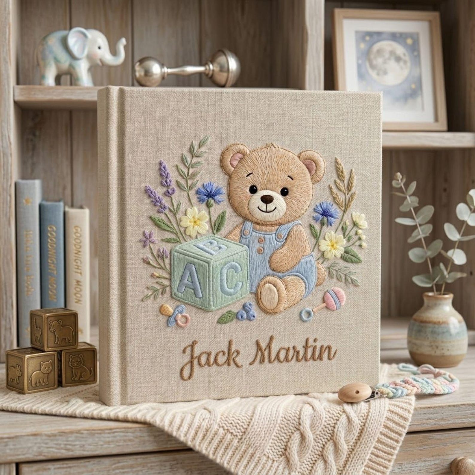 Personalized hand embroidered photo album featuring teddy bear in blue overalls with alphabet block and floral details on linen cover