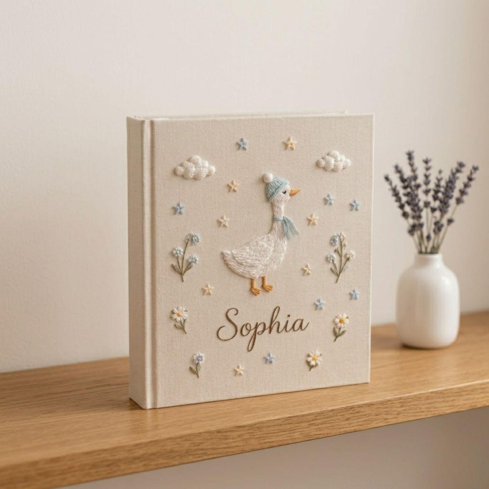 Personalized goose hand embroidered baby photo album with pastel balloons and floral meadow design on linen cover