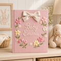 Personalized hand embroidered photo album featuring a floral name crest with pastel flowers and elegant bow on a pink linen cover