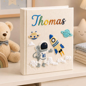 Personalized hand embroidered photo album featuring astronaut rocket ship planets and custom baby name on linen cover