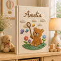 Personalized embroidered baby photo album featuring teddy bear holding butterfly net surrounded by flowers and butterflies