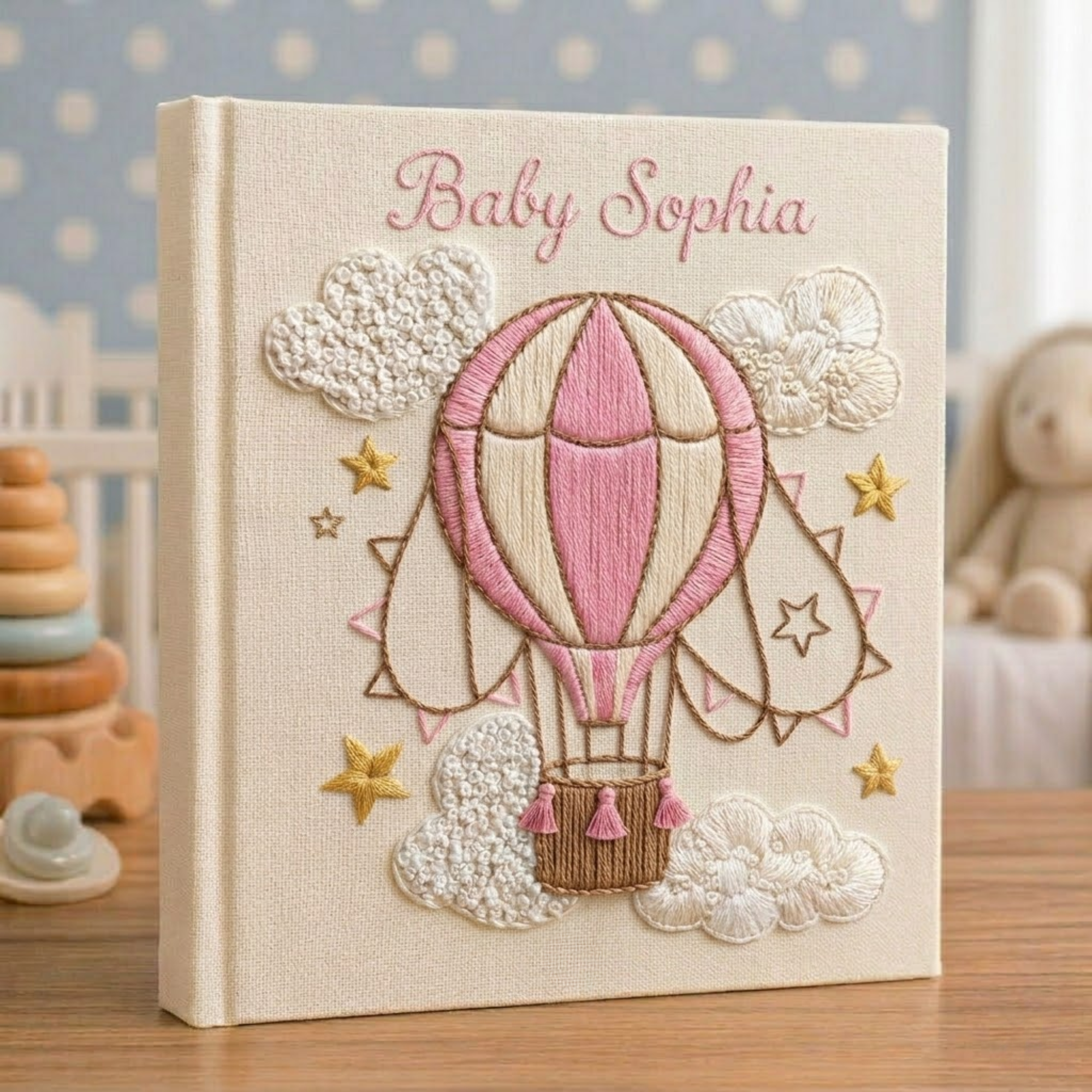 Personalized hand embroidered photo album featuring a vintage hot air balloon floating among clouds and stars on a linen cover