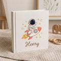 Personalized hand embroidered baby photo album with astronaut riding rocket and stars nursery design