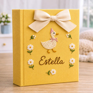 Personalized yellow hand embroidered baby photo album with duckling, daisies, and decorative bow