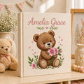 Personalized embroidered baby photo album with teddy bear holding pink flowers and floral nursery design