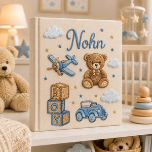 Personalized hand embroidered photo album featuring teddy bear, toy airplane, vintage car, alphabet blocks and nursery stars in blue tones