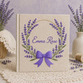 Personalized hand embroidered photo album featuring a lavender floral wreath with an elegant purple bow on a premium linen cover customized with a name