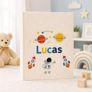 Personalized hand embroidered photo album featuring astronaut rockets planets stars and custom child name on linen cover