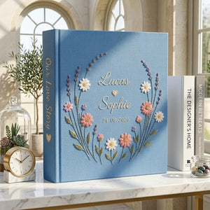 Personalized hand embroidered wedding photo album with floral wreath design, custom names and wedding date on blue linen cover