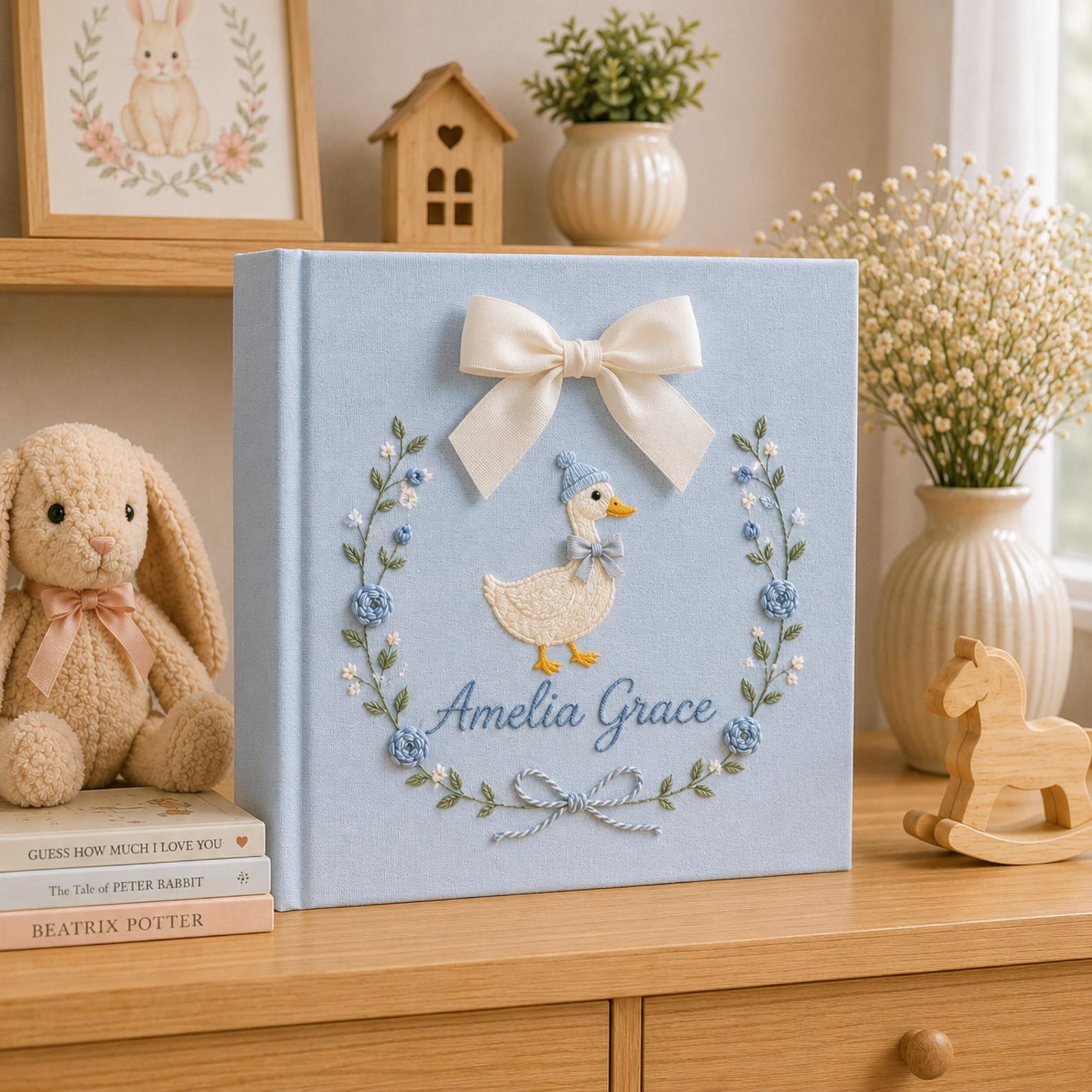 Personalized pink hand embroidered baby photo album with duckling, floral wreath, and ribbon bow