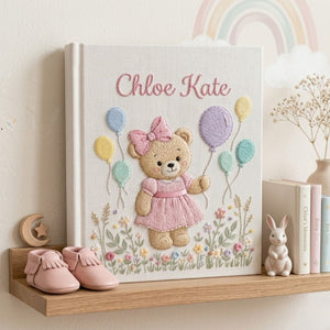 Personalized hand embroidered photo album featuring a birthday teddy bear holding pastel balloons in a blooming flower garden