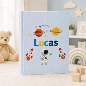 Personalized hand embroidered photo album featuring astronaut rockets planets stars and custom child name on linen cover
