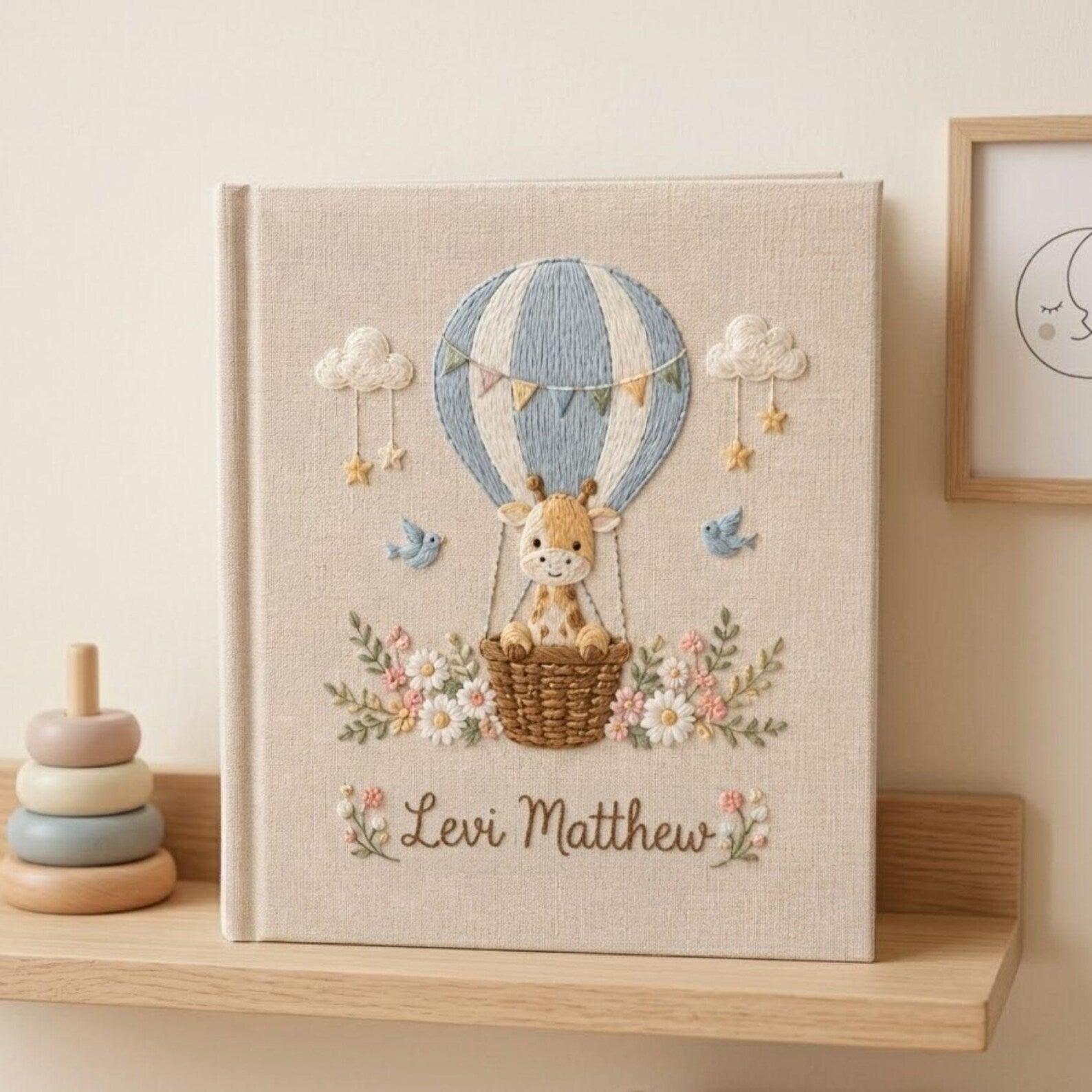 Personalized hand embroidered photo album featuring a baby giraffe in a hot air balloon with flowers clouds birds and custom name embroidery