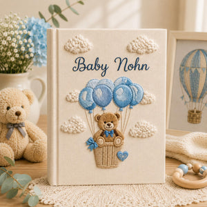 Personalized embroidered baby photo album with teddy bear in balloon basket and blue cloud nursery design