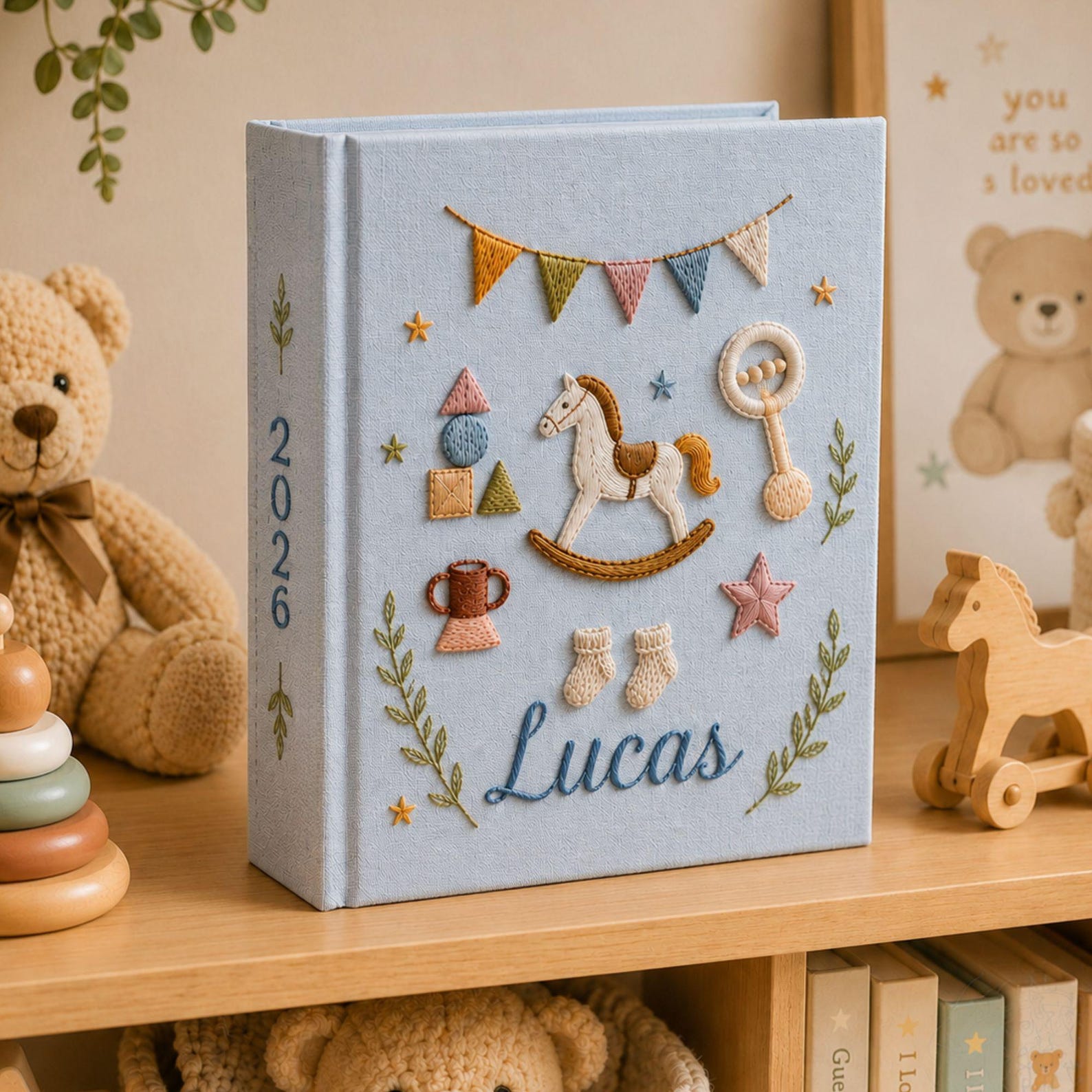 Personalized hand embroidered baby photo album with rocking horse, baby rattle, bunting flags, and vintage nursery toys