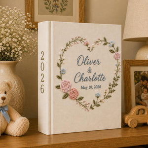 Personalized embroidered wedding photo album with floral heart wreath, pastel flower embroidery, custom names, wedding date, and linen hardcover design
