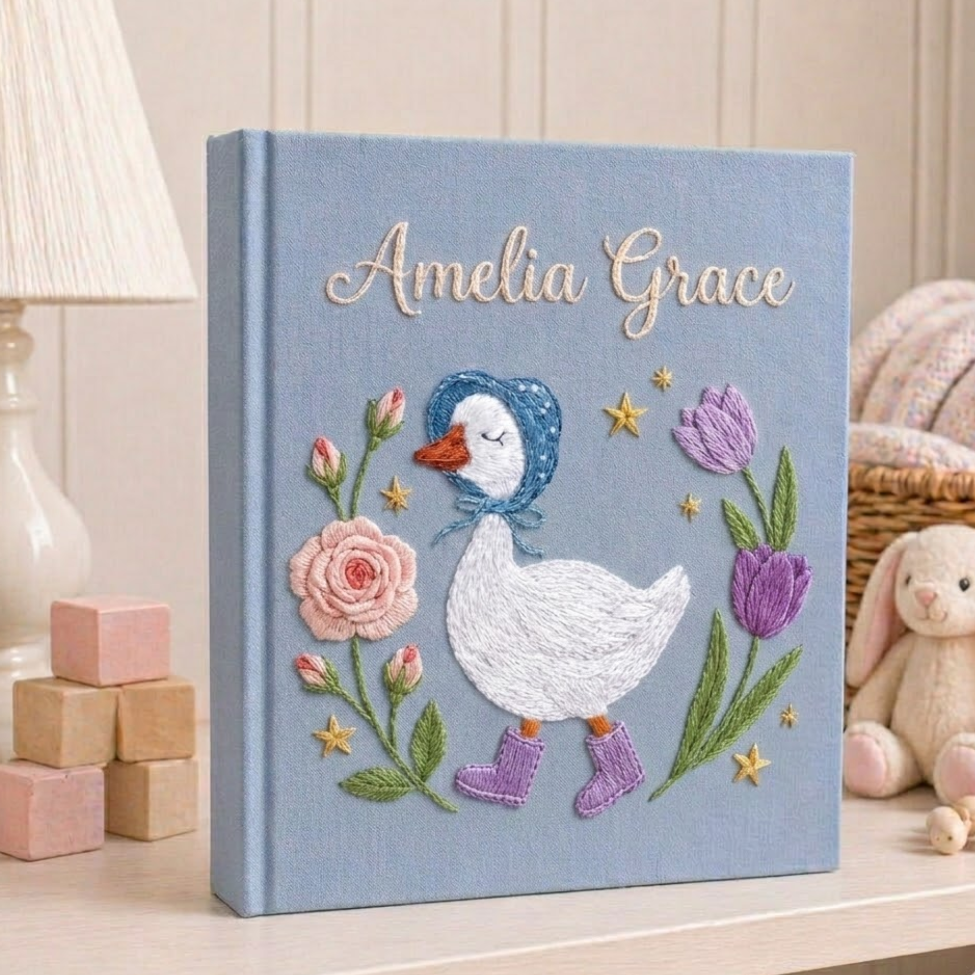 Personalized hand embroidered photo album featuring a bonnet goose walking through a whimsical storybook flower garden