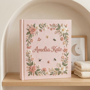 Personalized hand embroidered photo album featuring a floral garden wreath with bees, butterflies, delicate flowers and custom embroidered name on linen cover