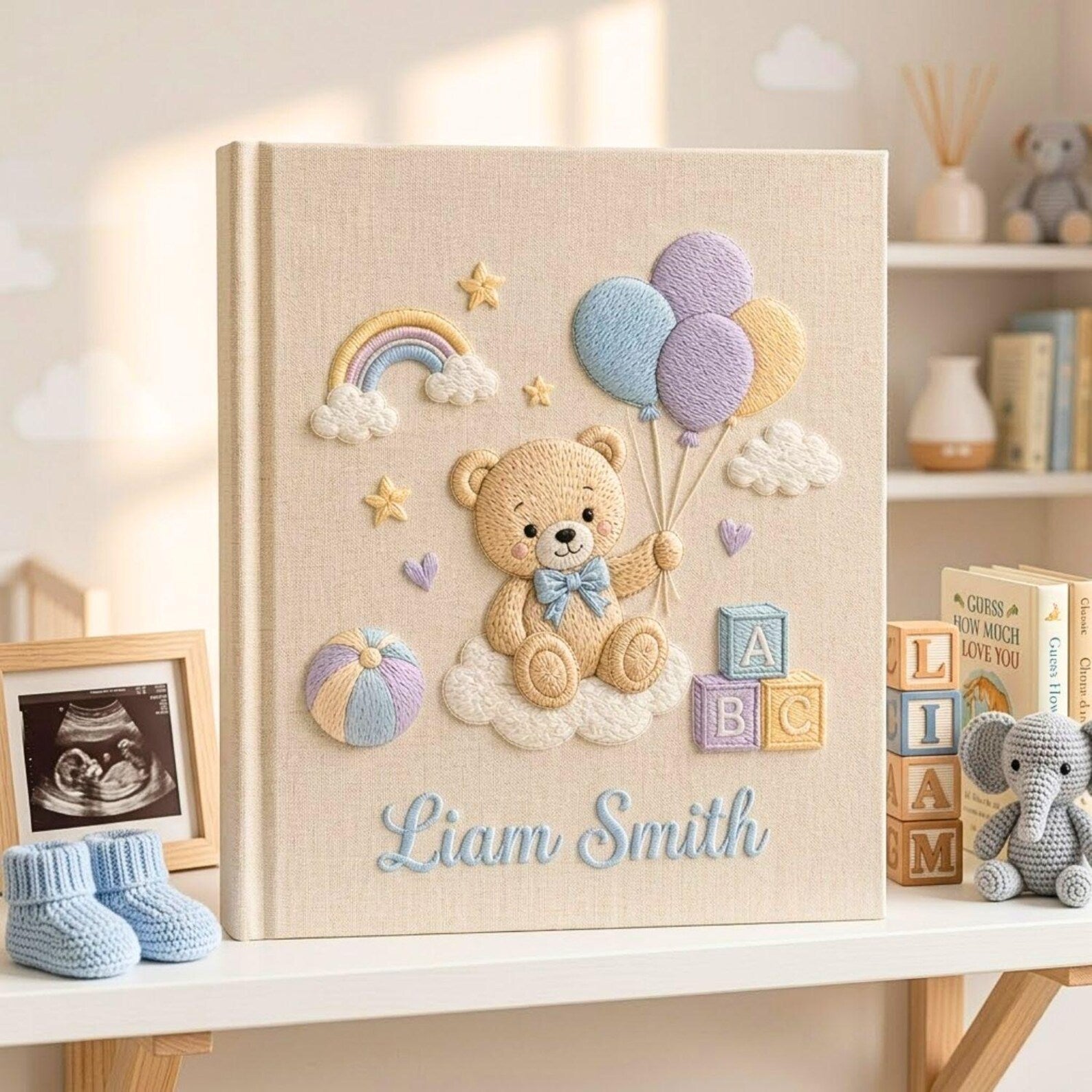 Personalized hand embroidered photo album featuring teddy bear holding pastel balloons with rainbow clouds ABC blocks and custom baby name