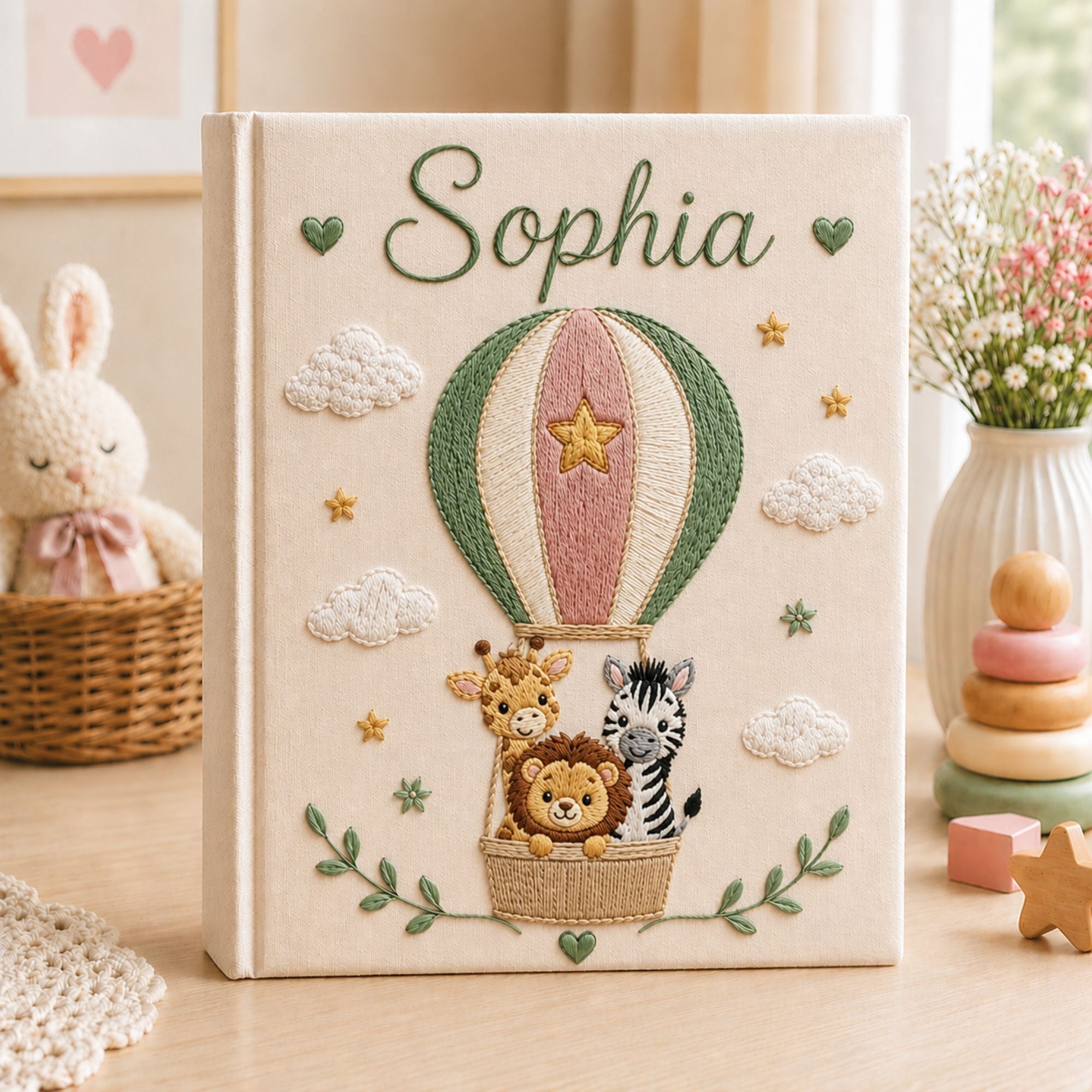 Personalized hand embroidered photo album featuring a lion giraffe and zebra riding in a hot air balloon with clouds stars and custom baby name on a linen cover