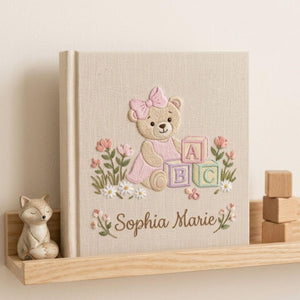 Personalized hand embroidered photo album featuring a teddy bear with pastel ABC blocks floral accents and custom name embroidery