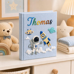 Personalized hand embroidered photo album featuring astronaut rocket ship planets and custom baby name on linen cover