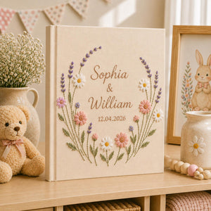 Custom lavender floral embroidered wedding photo albums with pastel botanical wreaths, daisy flowers, and personalized couple names on linen covers
