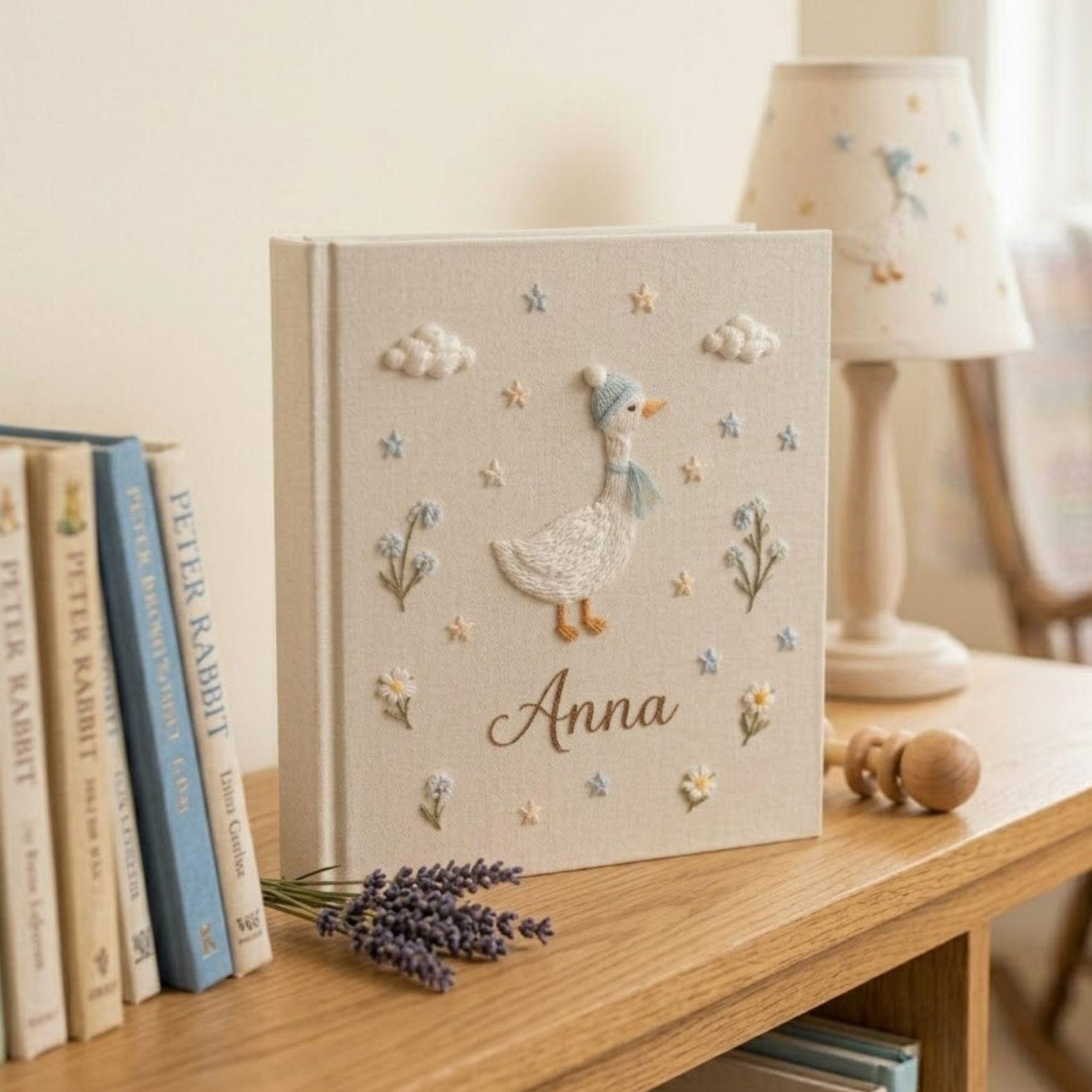 Personalized goose hand embroidered baby photo album with pastel balloons and floral meadow design on linen cover