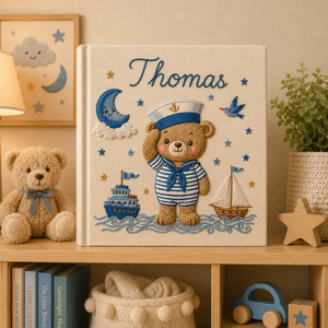 Personalized hand embroidered photo album featuring a sailor teddy bear captain with ships, sailboat, stars and ocean waves on a linen cover