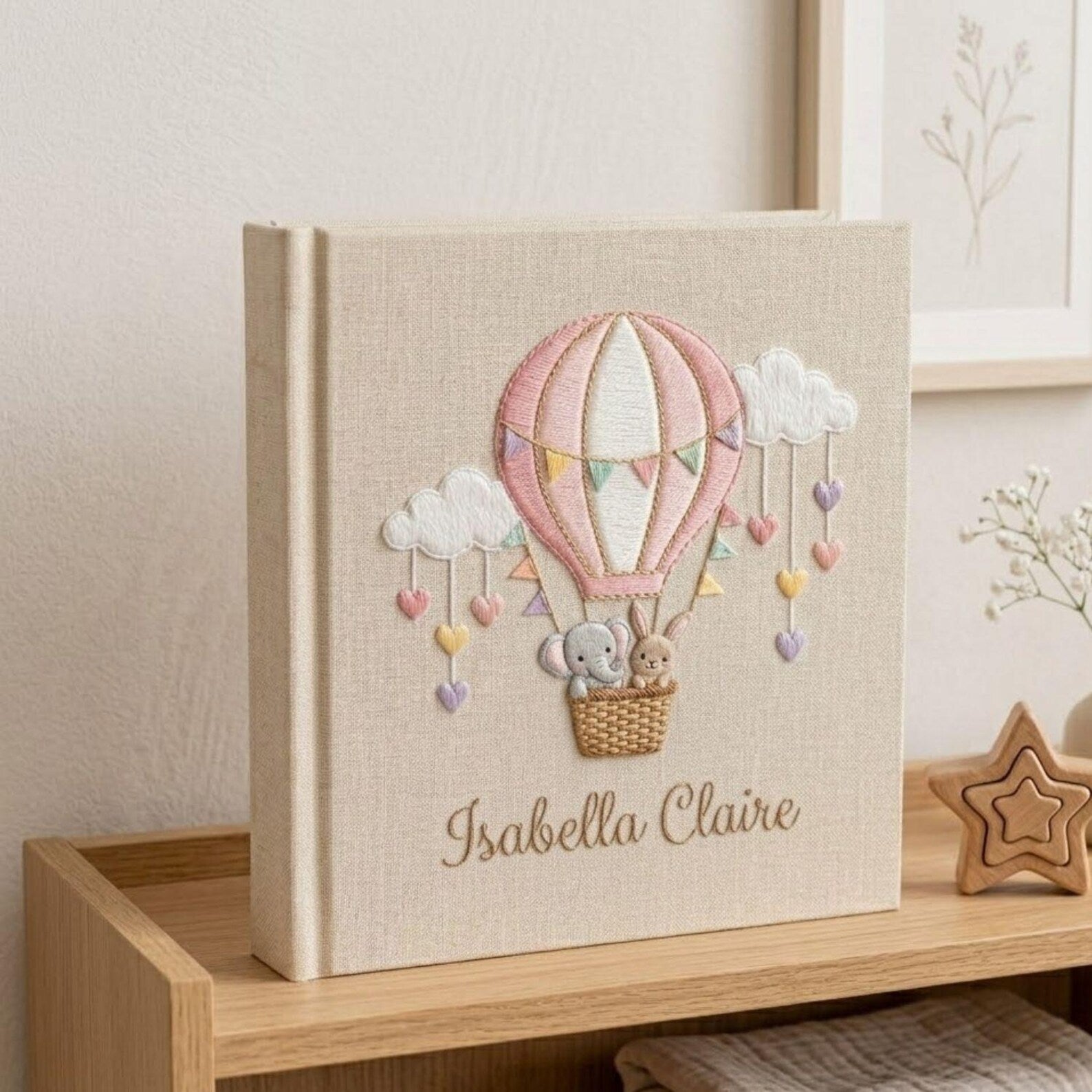 Personalized hand embroidered photo album featuring an elephant and bunny in a pastel hot air balloon with hanging hearts and custom name embroidery