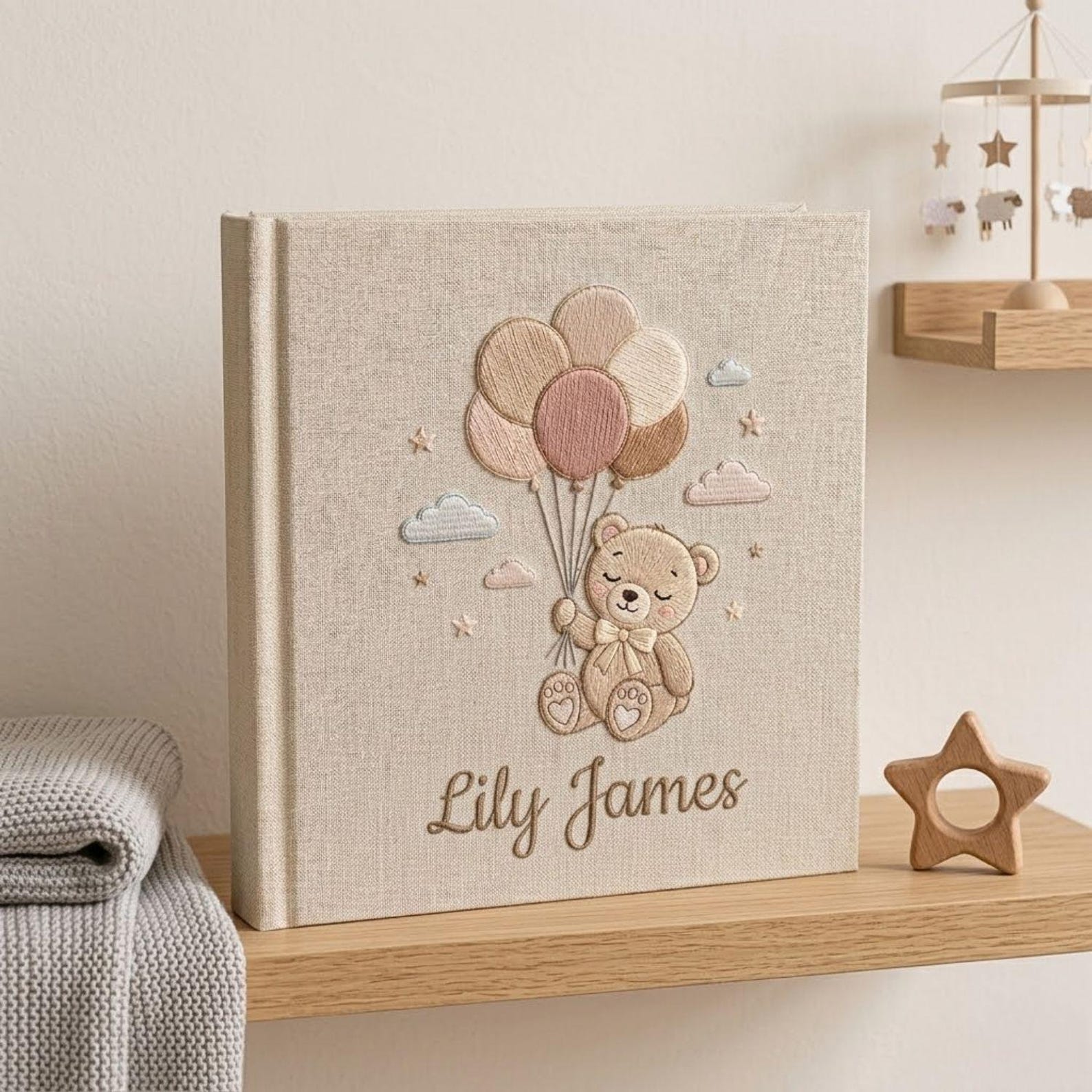 Personalized hand embroidered photo album featuring a teddy bear holding pastel balloons with custom embroidered baby name