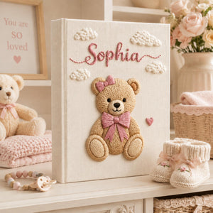 Personalized teddy bear hand embroidered newborn photo album with pink ribbon and soft cloud nursery design