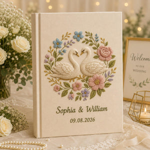 Personalized embroidered wedding photo album with floral swan embroidery, pastel botanical flowers, custom names, wedding date, and linen hardcover design