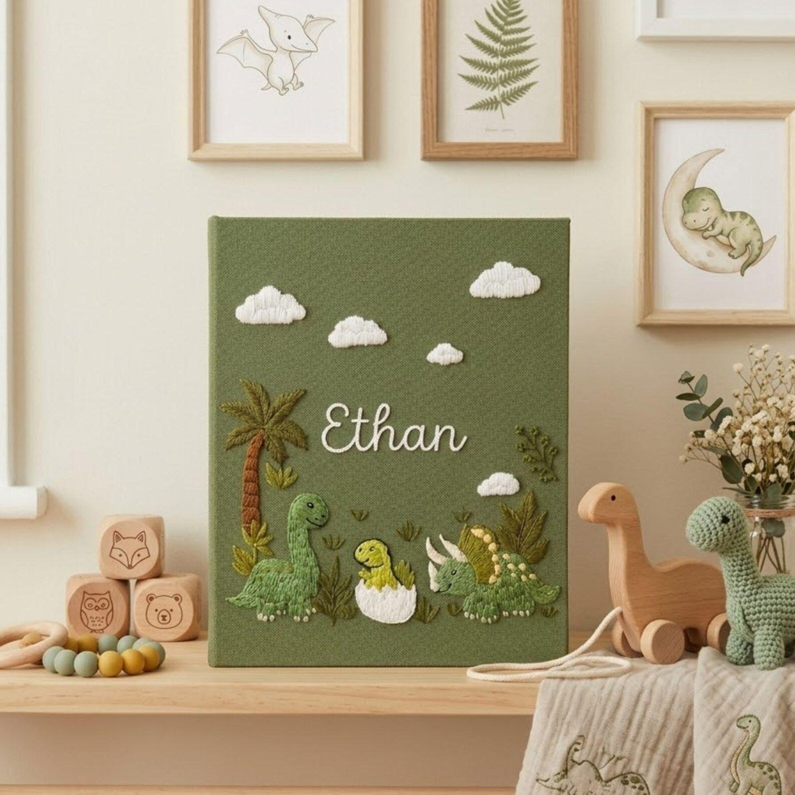 Personalized dinosaur hand embroidered baby photo album with cute prehistoric nursery design on green linen cover