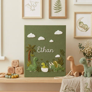Personalized dinosaur hand embroidered baby photo album with cute prehistoric nursery design on green linen cover
