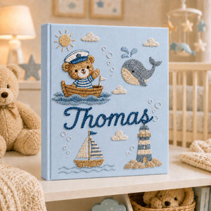 Personalized hand embroidered nautical baby photo album with sailor teddy bear, whale, sailboat, and lighthouse design
