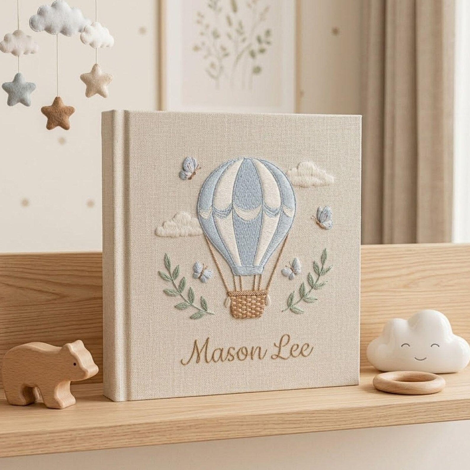 Personalized hand embroidered photo album featuring a blue hot air balloon with butterflies clouds and custom baby name
