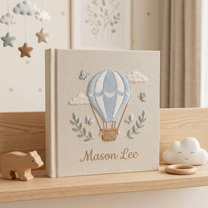 Personalized hand embroidered photo album featuring a blue hot air balloon with butterflies clouds and custom baby name