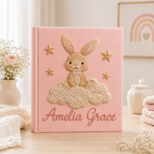 Personalized pink hand embroidered baby photo album with bunny sitting on fluffy clouds and stars