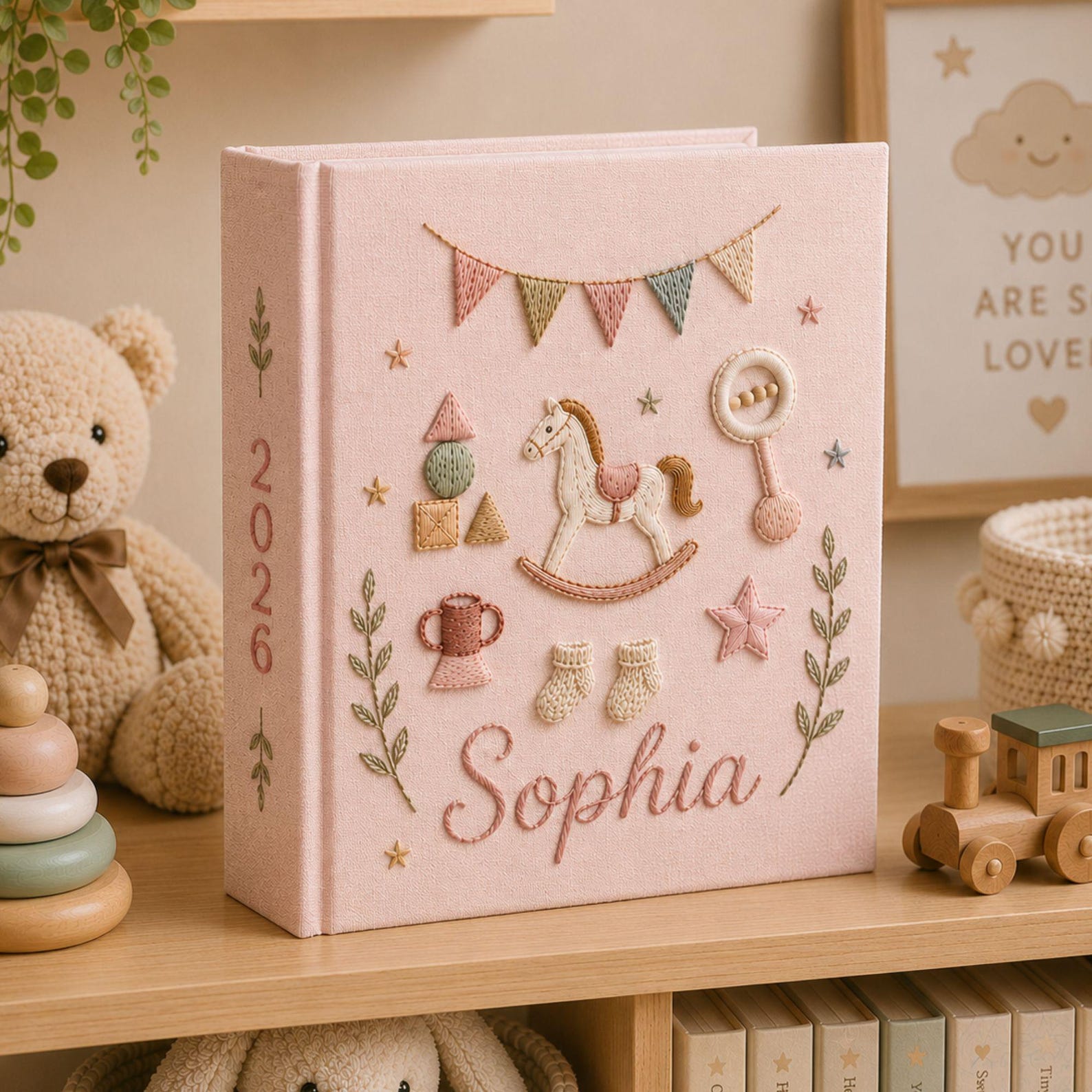 Personalized hand embroidered baby photo album with rocking horse, baby rattle, bunting flags, and vintage nursery toys