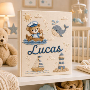 Personalized hand embroidered nautical baby photo album with sailor teddy bear, whale, sailboat, and lighthouse design
