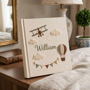Personalized adventure hand embroidered baby photo album with airplane hot air balloon and cloud design on linen cover